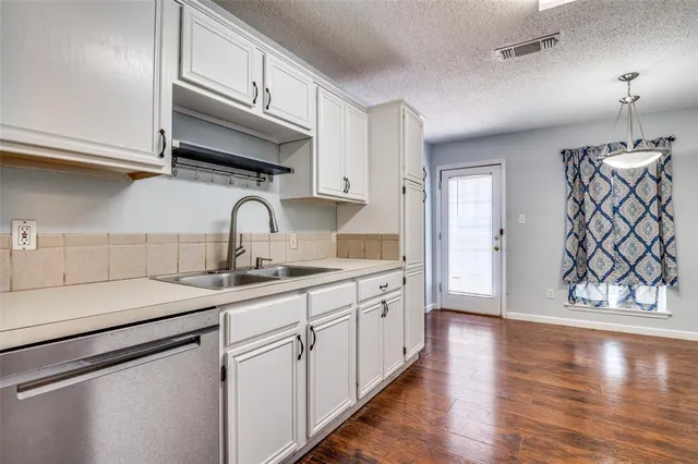 a kitchen with granite countertop a sink stainless steel appliances and cabinets