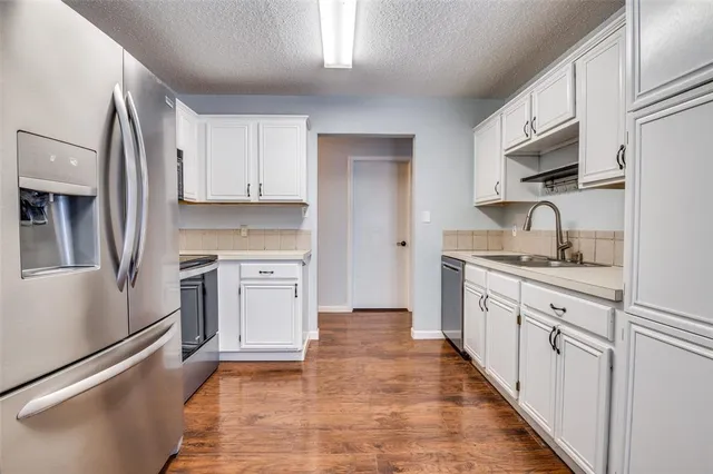 a view of a room with wooden floor electronic appliances and a window