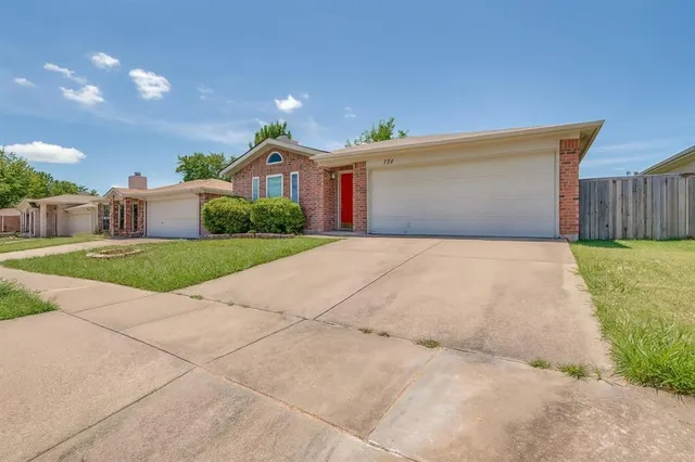 a view of a white house with a yard and potted plants