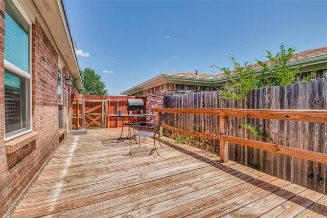 a view of a roof deck with wooden floor and fence