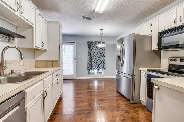 a kitchen with granite countertop a refrigerator stove and microwave