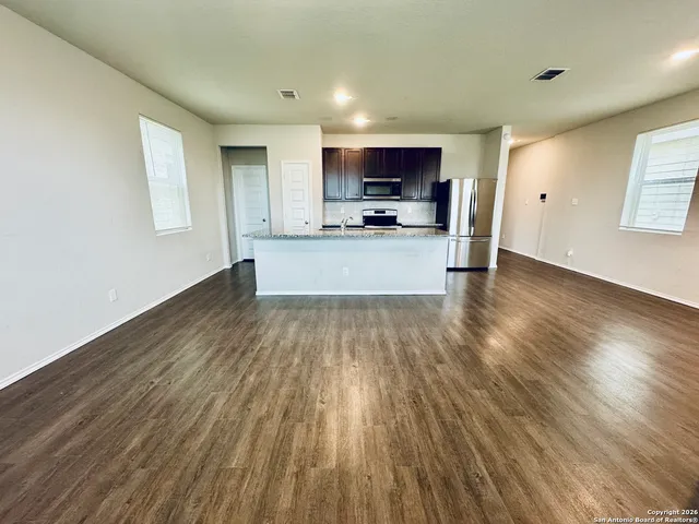 a view of kitchen with microwave a stove and wooden floor