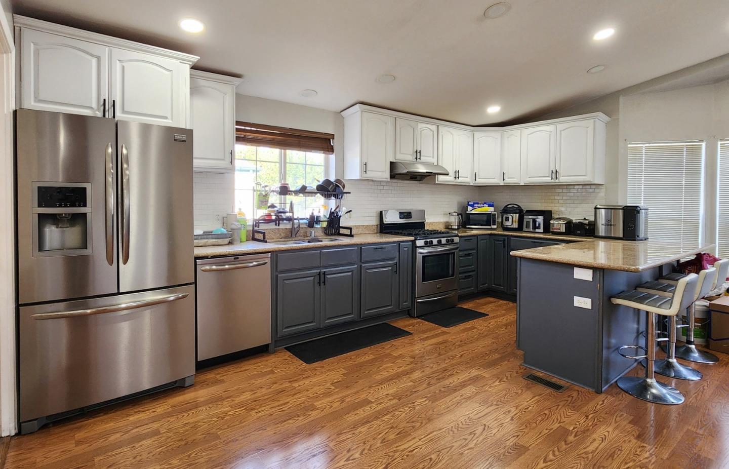 5450 Monterey Road, Unit 142 San Jose, CA 95111 - Photo 6 of 13 a kitchen with stainless steel appliances granite countertop a refrigerator a sink dishwasher a stove top oven a refrigerator with grey cabinets and wooden floor