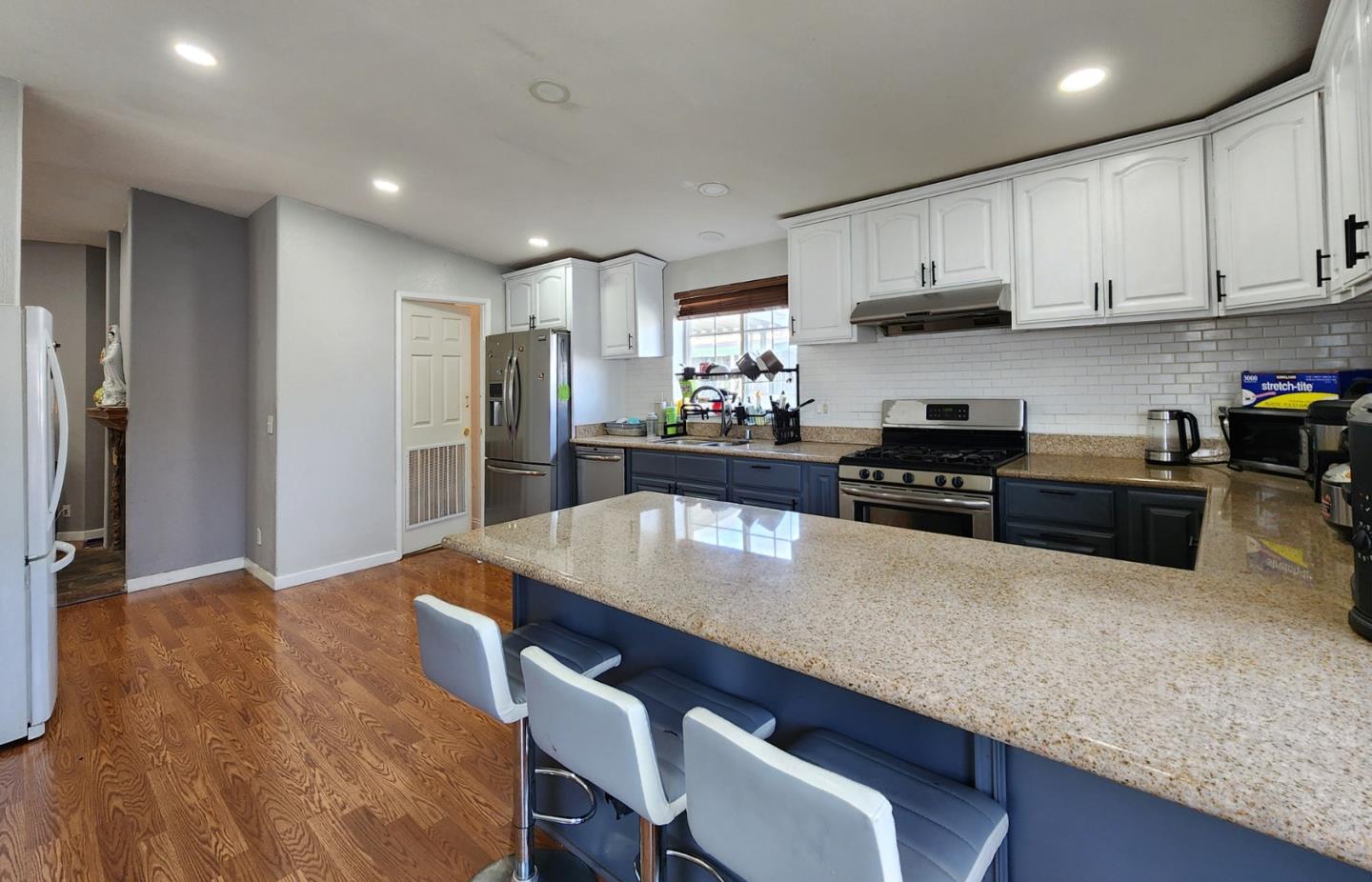 5450 Monterey Road, Unit 142 San Jose, CA 95111 - Photo 7 of 13 a kitchen with stainless steel appliances granite countertop a stove a refrigerator a sink a dining table and chairs