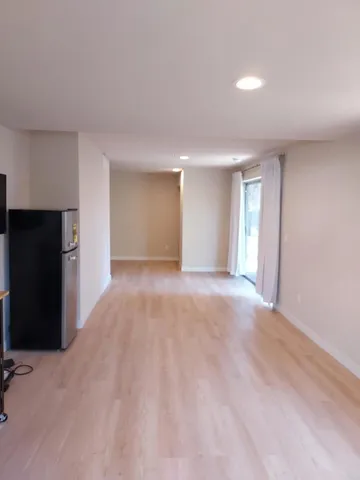 a view of an empty room with closet and a window