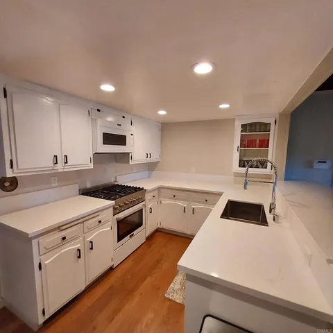 a kitchen with granite countertop white cabinets and white appliances