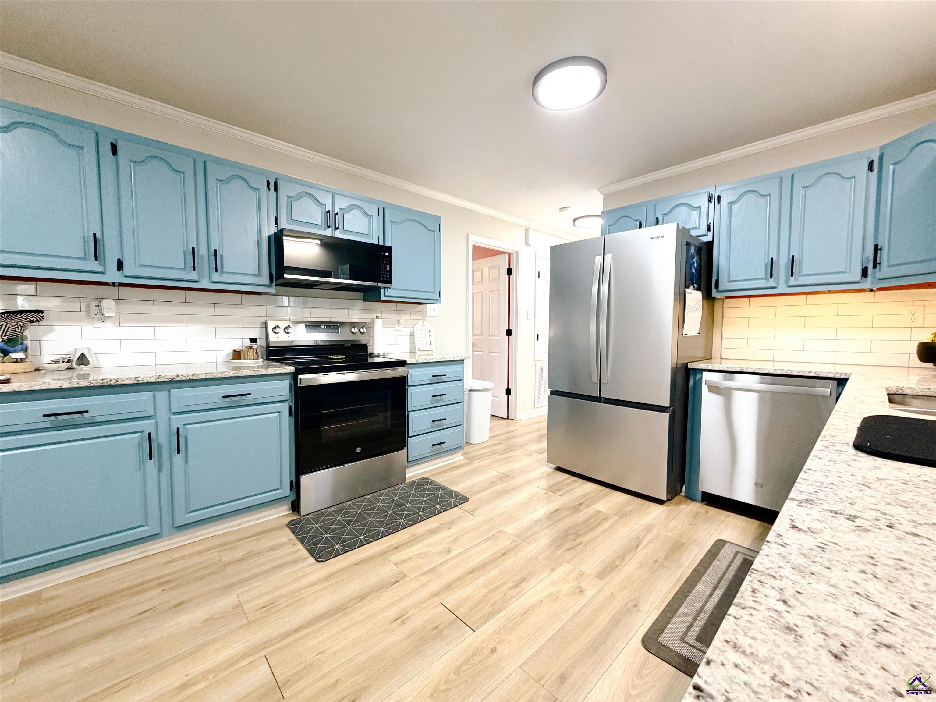 108 Weaver Road Warner Robins, GA 31093 - Photo 5 of 26 a kitchen with a refrigerator sink and wooden cabinets