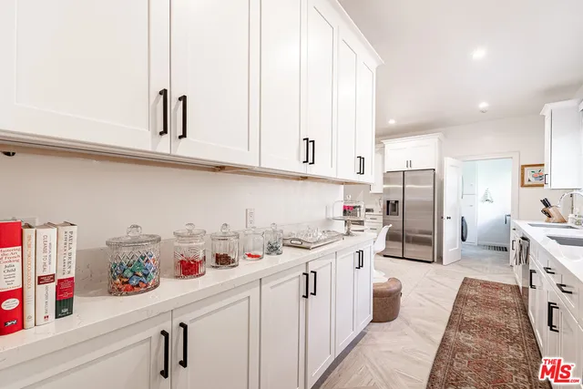 a kitchen with stainless steel appliances granite countertop a sink dishwasher stove and white cabinets