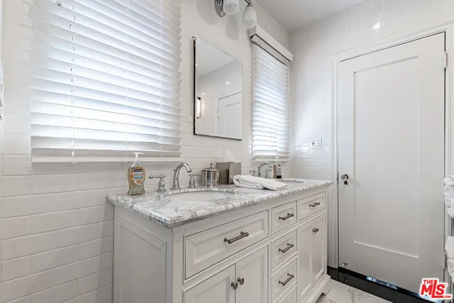 a bathroom with a granite countertop sink and a mirror