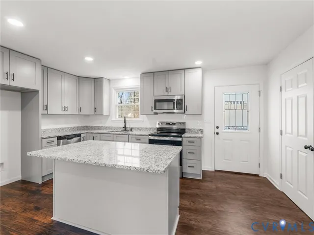 a kitchen with stainless steel appliances granite countertop a stove a sink and a refrigerator