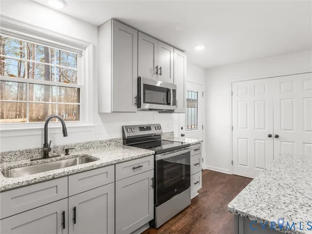 a kitchen with granite countertop cabinets stainless steel appliances and a sink