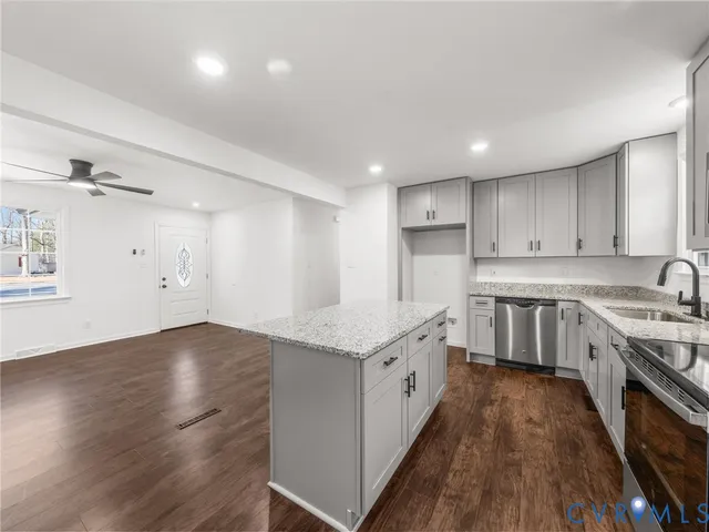 a large kitchen with stainless steel appliances granite countertop a stove a sink dishwasher and a oven with white cabinets