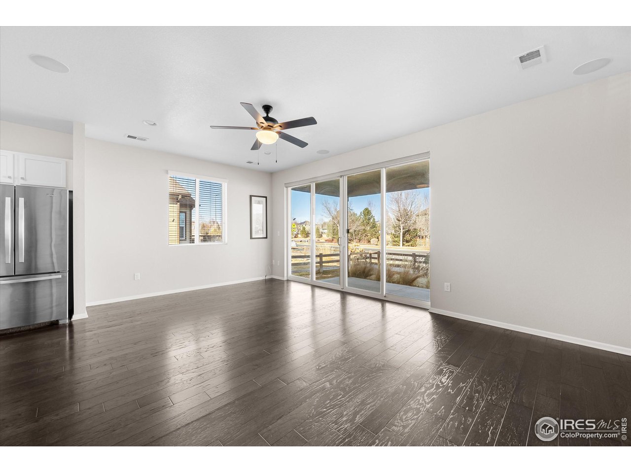 1604 Sorenson Drive Windsor, CO 80550 - Photo 14 of 32 a view of an empty room with a window and wooden floor