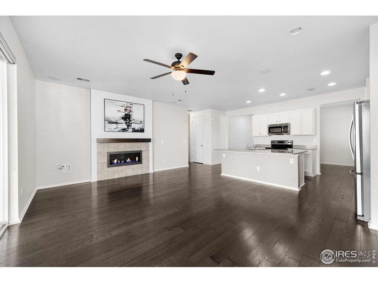 1604 Sorenson Drive Windsor, CO 80550 - Photo 17 of 32 a kitchen with kitchen island white cabinets and appliances