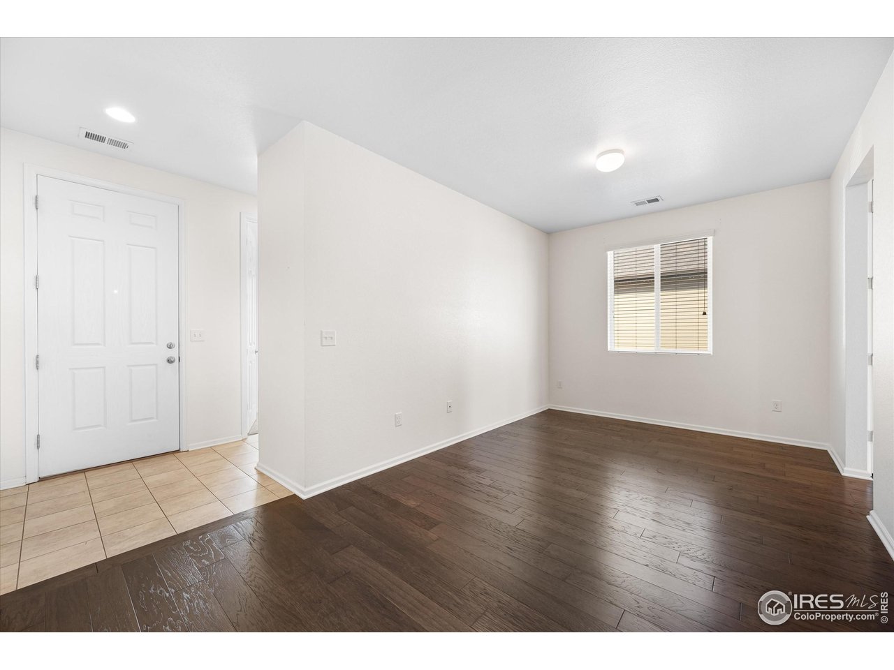 1604 Sorenson Drive Windsor, CO 80550 - Photo 6 of 32 a view of an empty room with wooden floor and a window