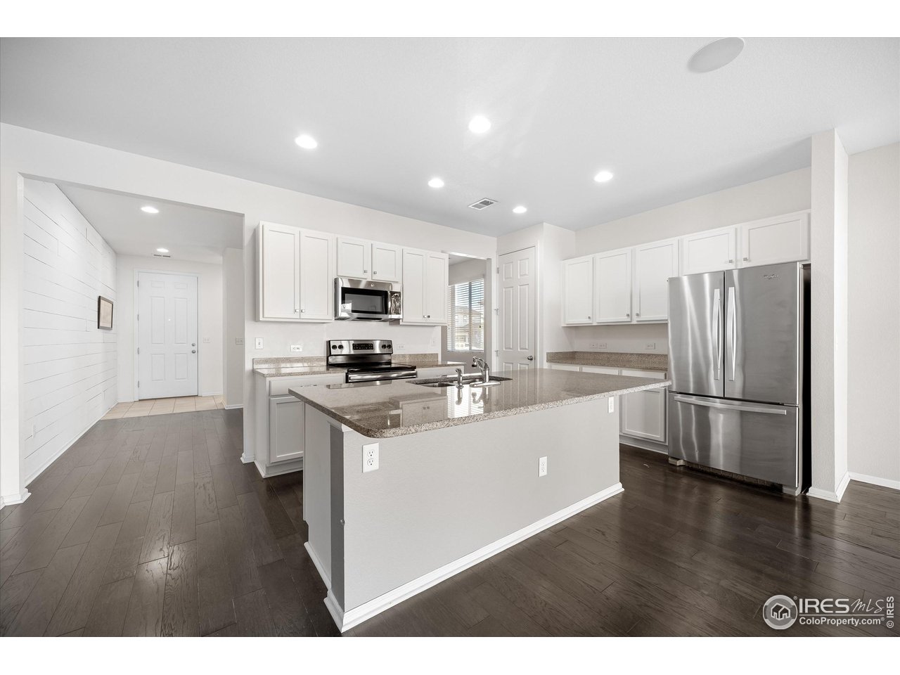 1604 Sorenson Drive Windsor, CO 80550 - Photo 9 of 32 a kitchen with stainless steel appliances kitchen island sink refrigerator and microwave