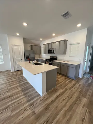 a large kitchen with stainless steel appliances granite countertop a large counter top and a stove top oven