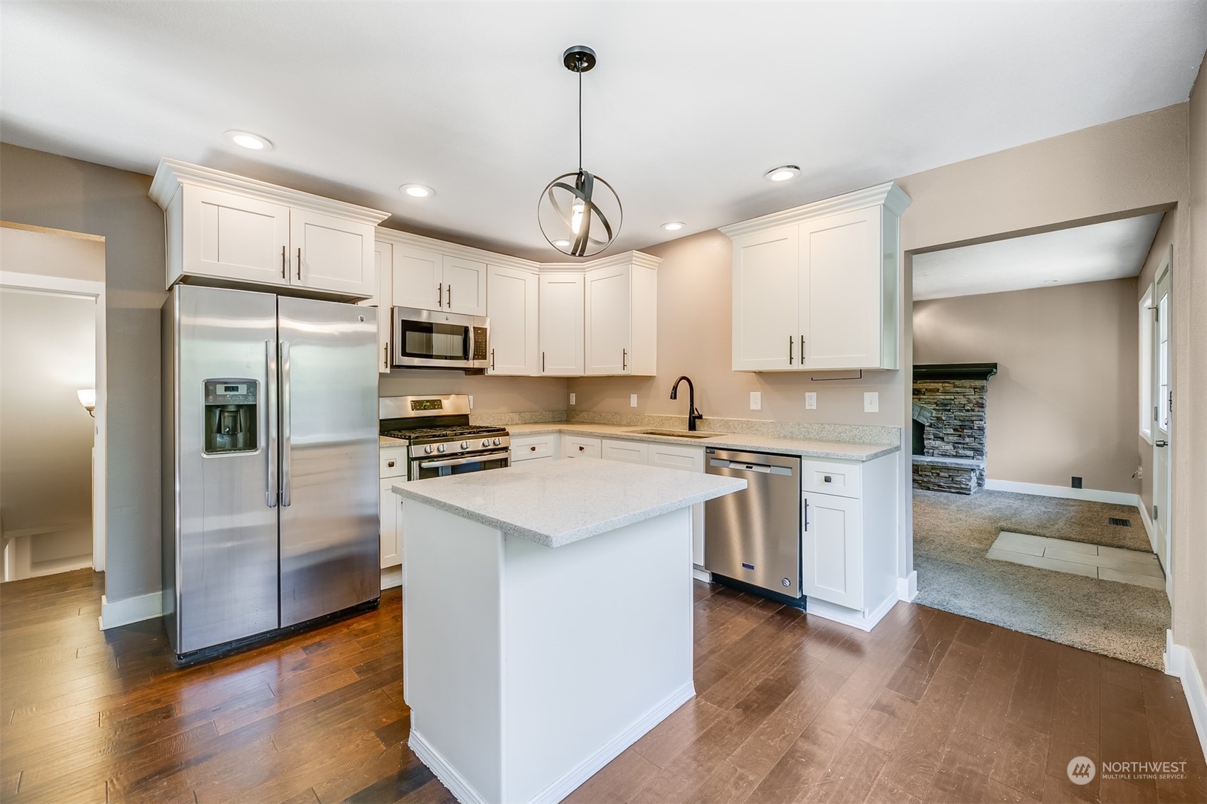 2528 Southwest 112th Street Seattle, WA 98146 - Photo 4 of 33 a kitchen with a refrigerator a sink dishwasher a stove and white cabinets with wooden floor