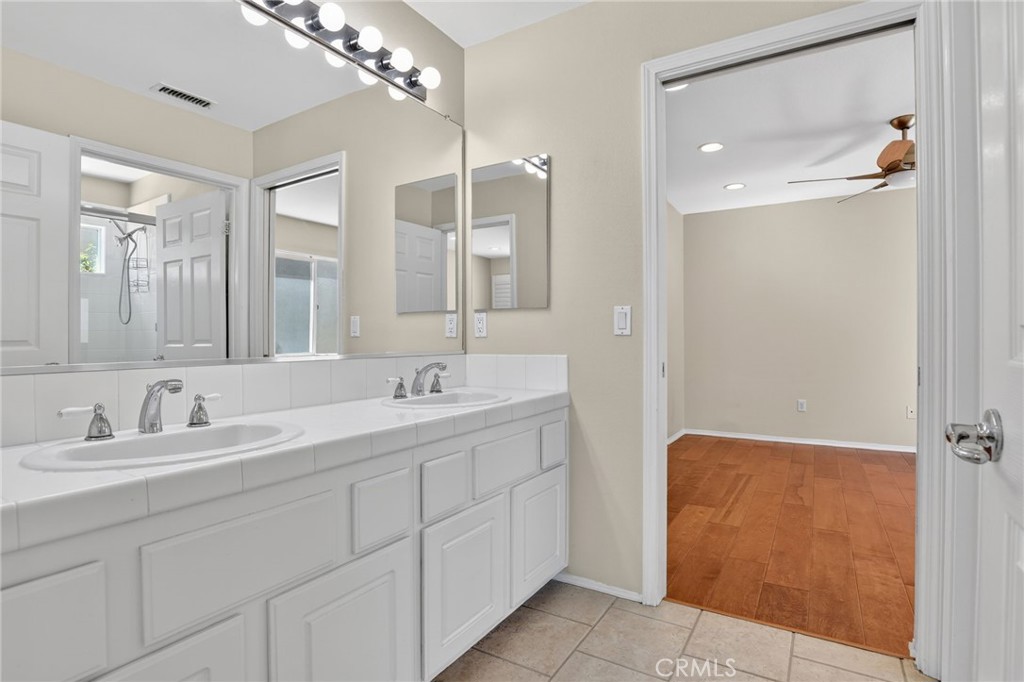 20543 Pesaro Porter Ranch Porter Ranch, CA 91326 - Photo 49 of 67 a bathroom with a double vanity sink a mirror and a shower