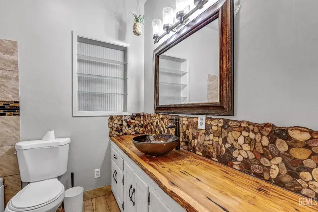 a bathroom with a granite countertop toilet sink and mirror