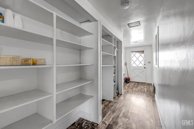 a view of a hallway with wooden floor and closet