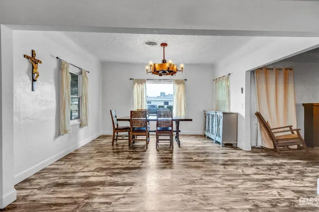 a dining room with furniture a chandelier and wooden floor
