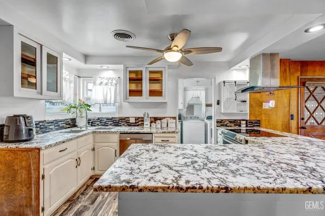 a kitchen with stainless steel appliances granite countertop a sink stove and refrigerator