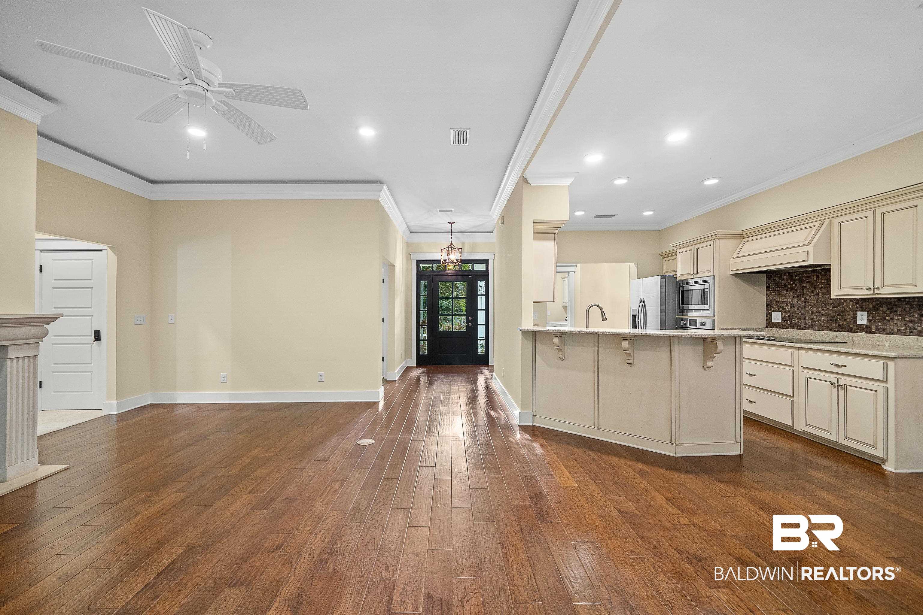 356 Liberty Street Fairhope, AL 36532 - Photo 38 of 39 Kitchen with ornamental molding, a kitchen bar, backsplash, open floor plan, and a peninsula