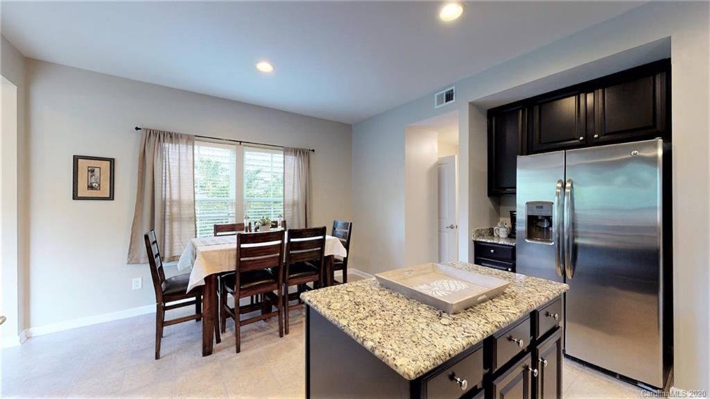 3012 Fallondale Road Waxhaw, NC 28173 - Photo 22 of 47 a kitchen with granite countertop kitchen island stainless steel appliances a table chairs and refrigerator
