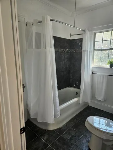 a bathroom with a shower a toilet and bathtub