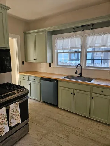 a kitchen with a sink stove top oven and cabinets