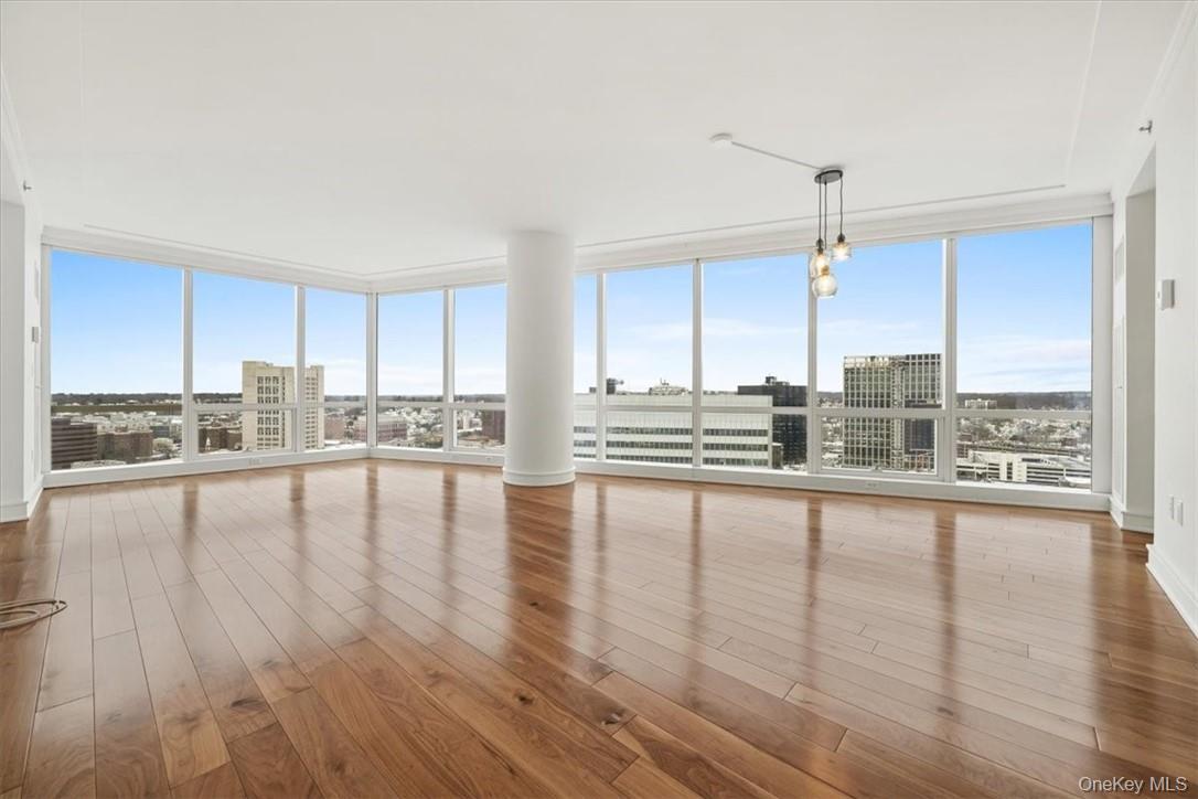a view of a kitchen with kitchen island granite countertop wooden floors and a view of living room