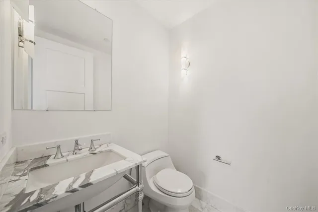 a white toilet sitting next to a bathroom sink
