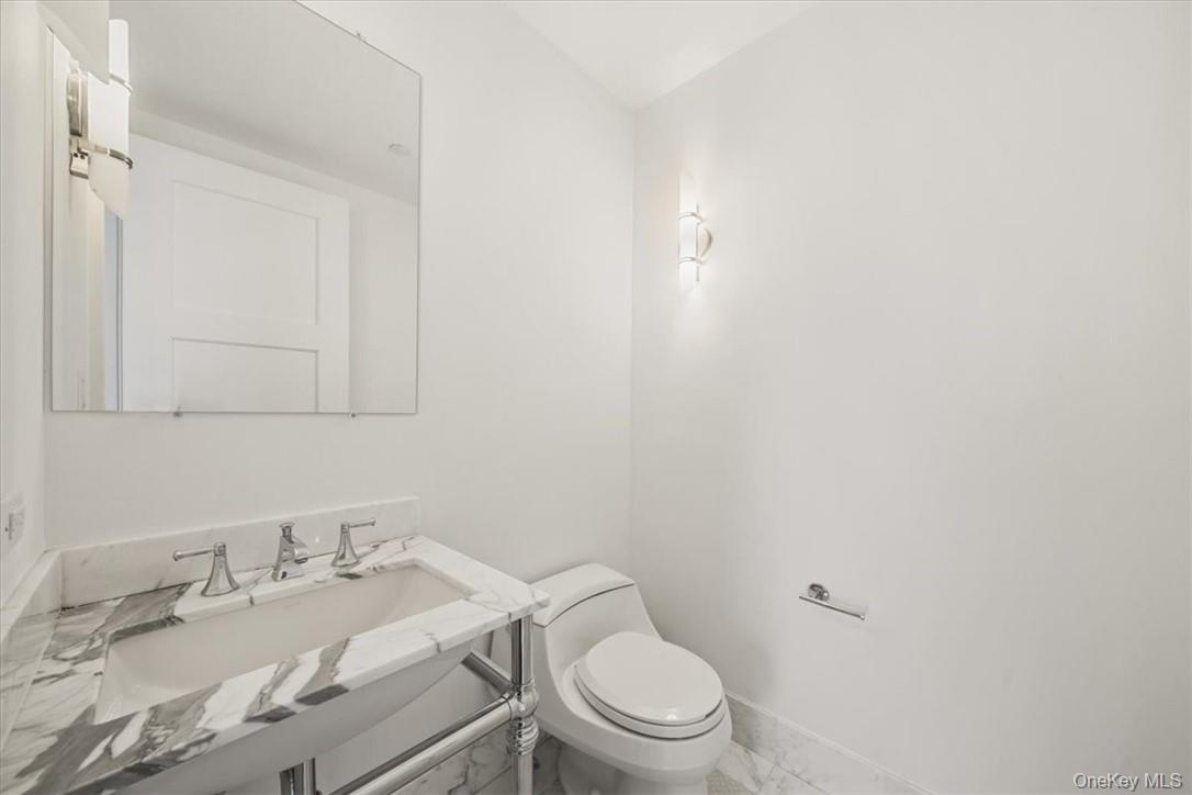 5 Renaissance Square, Unit 21E White Plains, NY 10601 - Photo 18 of 34 a white toilet sitting next to a bathroom sink