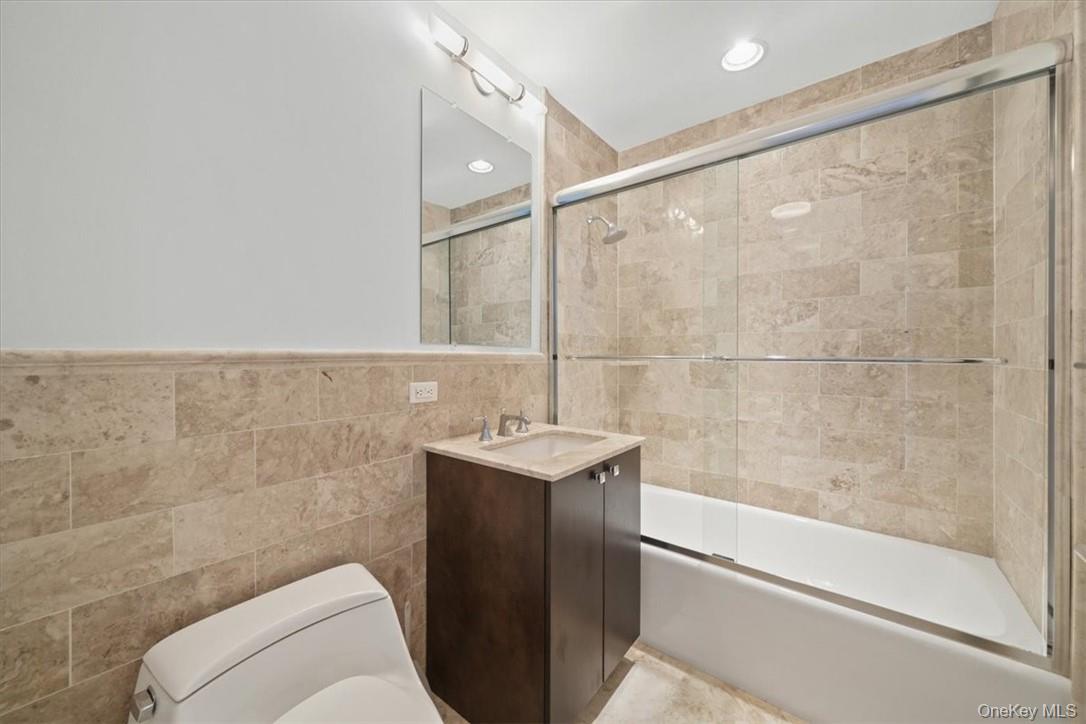 5 Renaissance Square, Unit 21E White Plains, NY 10601 - Photo 20 of 34 a bathroom with a sink mirror toilet and bathtub