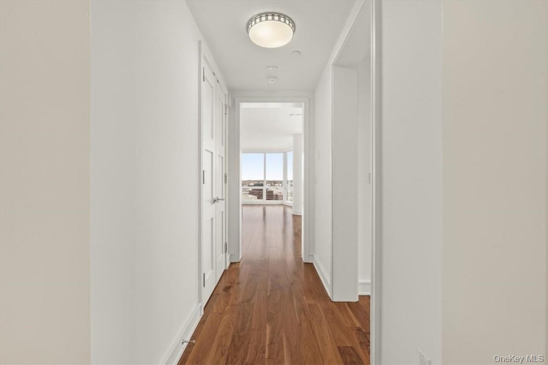 5 Renaissance Square, Unit 21E White Plains, NY 10601 - Photo 2 of 34 a view of a hallway with wooden floor and a bathroom