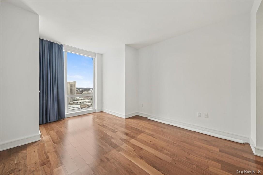 5 Renaissance Square, Unit 21E White Plains, NY 10601 - Photo 22 of 34 a view of an empty room with wooden floor