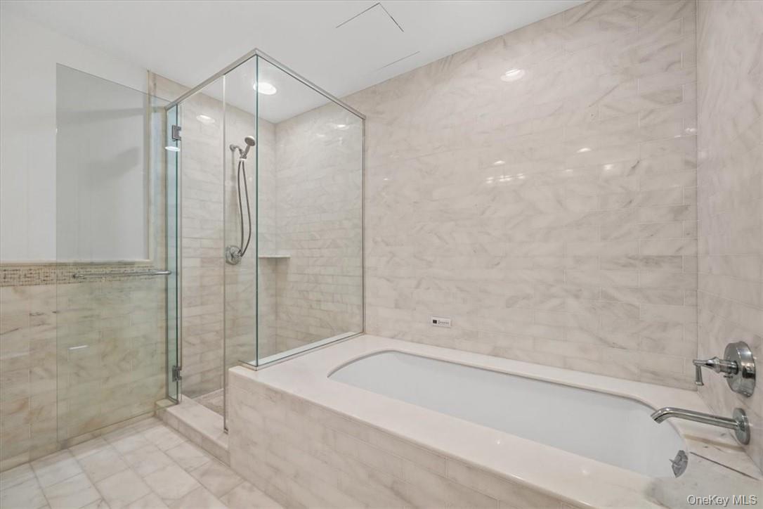 5 Renaissance Square, Unit 21E White Plains, NY 10601 - Photo 30 of 34 a bathroom with a bathtub and a shower