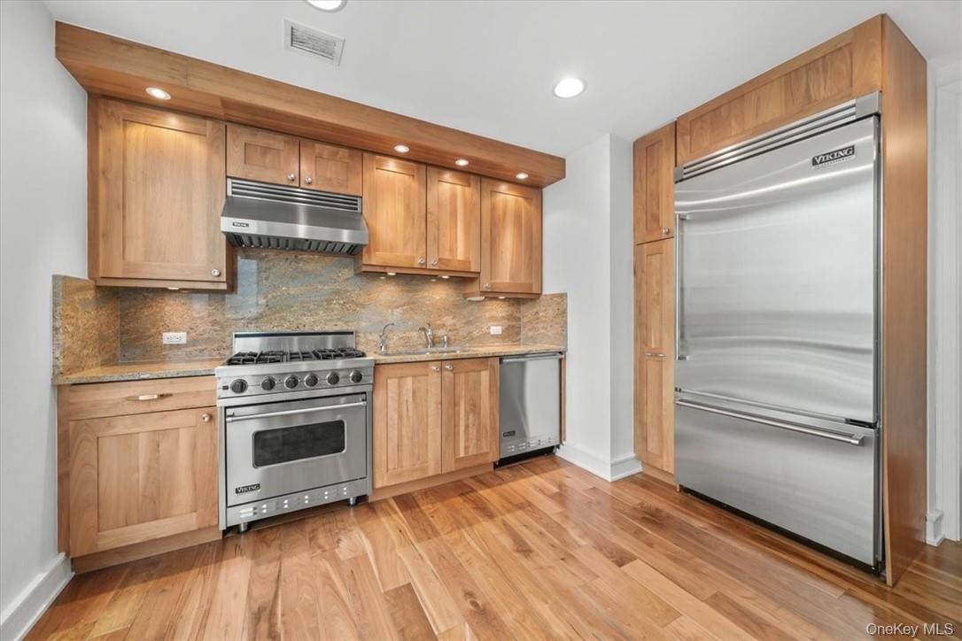 5 Renaissance Square, Unit 21E White Plains, NY 10601 - Photo 7 of 34 a kitchen with stainless steel appliances granite countertop a stove and a refrigerator