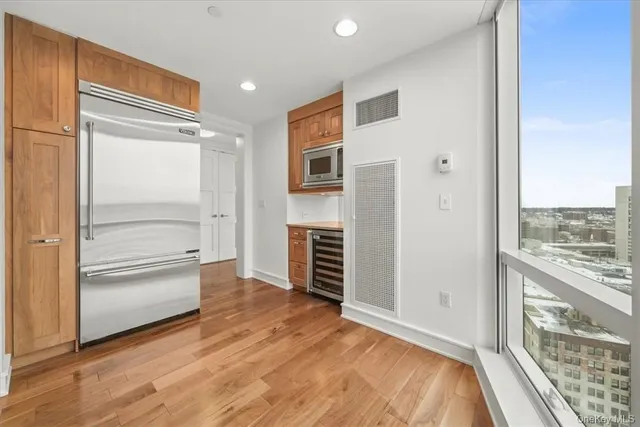 a view of a hallway with an empty room and wooden floor