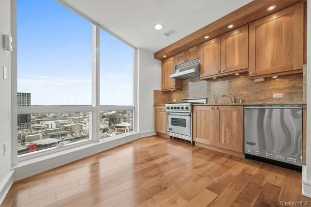 a kitchen with stainless steel appliances a stove top oven