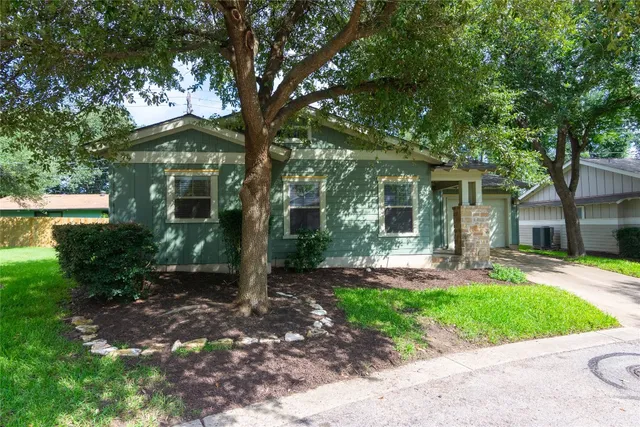 a front view of a house with yard and green space