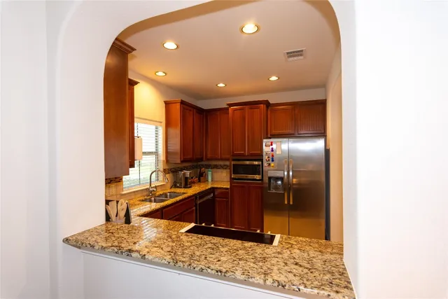 a kitchen with stainless steel appliances granite countertop a sink stove and refrigerator