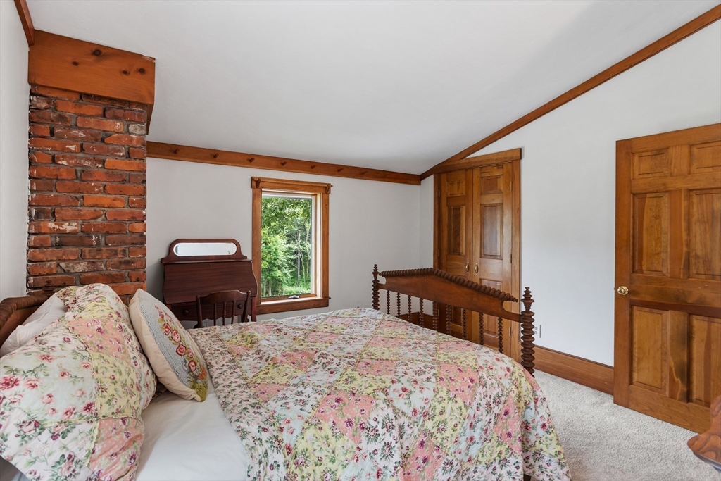 292 Berlin Road Bolton, MA 01740 - Photo 25 of 42 a bedroom with a bed and a dresser with mirror
