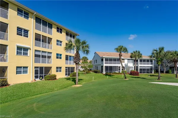 a front view of building with yard and outdoor seating