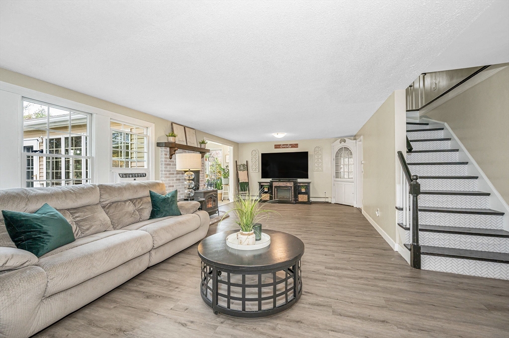16 Old Lowell Road Westford, MA 01886 - Photo 13 of 41 a living room with furniture a flat screen tv and a large window