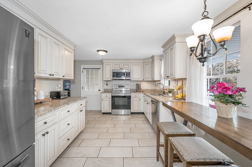 16 Old Lowell Road Westford, MA 01886 - Photo 3 of 41 a kitchen with granite countertop white cabinets stainless steel appliances and dining table