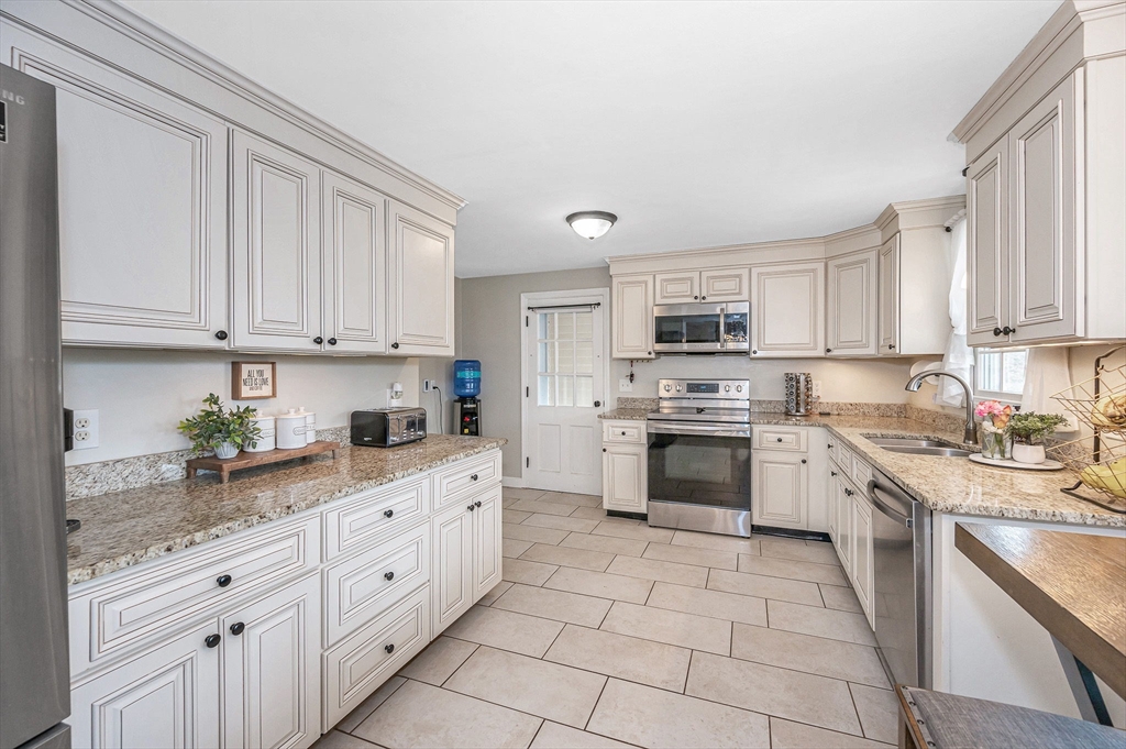 16 Old Lowell Road Westford, MA 01886 - Photo 4 of 41 a kitchen with granite countertop white cabinets and white stainless steel appliances