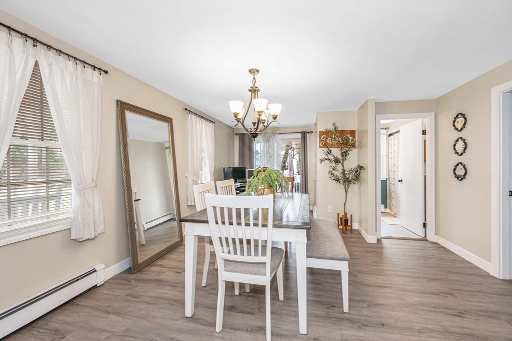 16 Old Lowell Road Westford, MA 01886 - Photo 7 of 41 a dining room with wooden floor a chandelier a wooden table and chairs