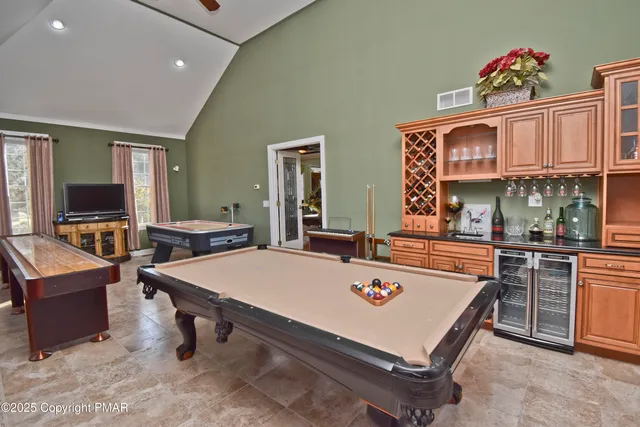a bed room with a bed mirror and a flat tv screen on dresser